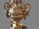 a gold vase with a handle and a chain hanging from it