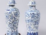 pair of blue and white vases with lids on stands