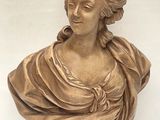 bronze bust of a woman in a dress on a stand