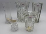 three glass vases and a glass candle holder on a white surface