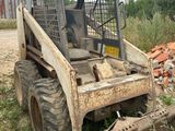 a small tractor that is parked in the dirt
