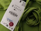 a tag on a green fabric with a black button