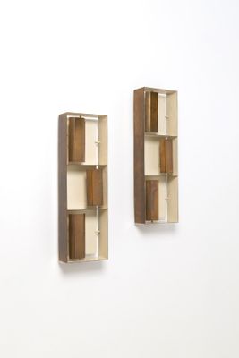 une paire d'étagères en bois fixées au mur d'une pièce blanche