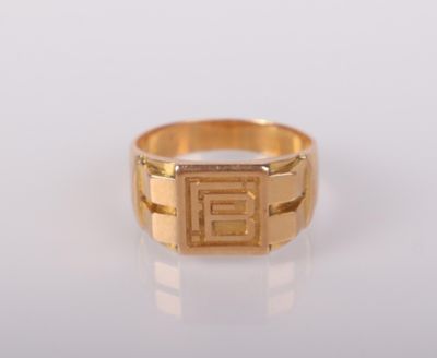 une bague en or sur laquelle est gravée la lettre « e »