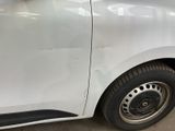 a white car that has been dented and is parked in a garage