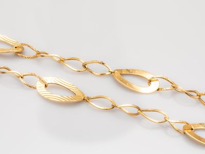 a close up of a gold chain on a white surface