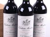 trois bouteilles de vin rouge posées à côté d'une caisse en bois