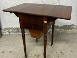 une petite table en bois avec un tiroir