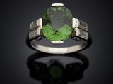 un gros plan sur une bague en tourmaline verte et diamants
