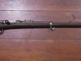 an old rifle is laying on a wooden floor next to a wall