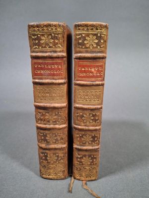 paire de livres anciens reliés en cuir, avec des reliures dorées et rouges