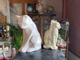 two statues of cats sitting on a table in a living room