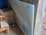 a pile of wood next to a blue door