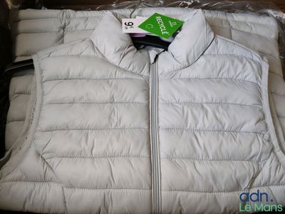 un gilet blanc avec une étiquette verte, dans une boîte