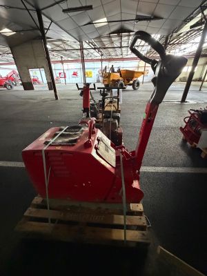 a red machine that is sitting on a pallet in a warehouse