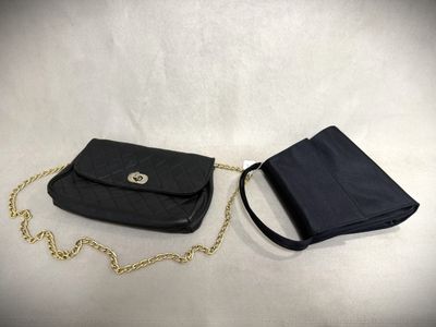 a black purse and wallet sitting on a white surface
