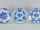 trois assiettes bleues et blanches ornées de fleurs, posées sur une table