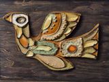 a bird made of clay sitting on a wooden table