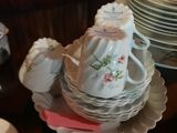 many plates and cups sitting on a table with a teapot