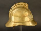 gold helmet on a stand against a black background