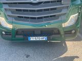 a green truck parked in a parking lot next to a building