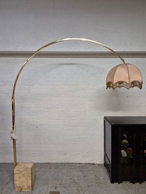 Lampadaire arqué en métal doré reposant sur une base rectang…
