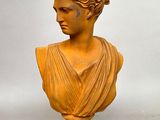 statue d'une femme vêtue d'une robe drapée sur fond blanc