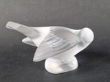 a glass bird that is sitting on a table
