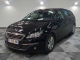 La voiture noire est garée sur le sol à damier du garage.