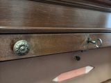 a close up of a wooden dresser with many drawers