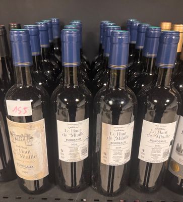 several bottles of wine are lined up on a shelf in a store
