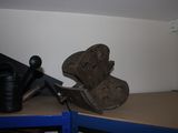 a shoe that is sitting on a shelf next to a watering can