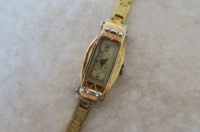 une montre posée sur une surface blanche