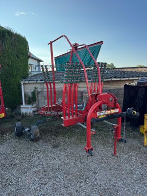 a red cart that is sitting in the gravel
