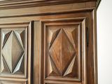 a wooden armoire with a mirror on top of it