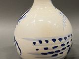 a blue and white vase next to a small bowl