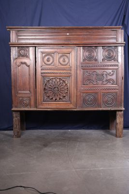une grande armoire en bois dont la façade est ornée de sculptures