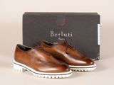 une paire de chaussures marron à semelles blanches posée devant une boîte