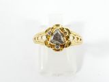 un gros plan d'une bague en or sertie d'un diamant gris