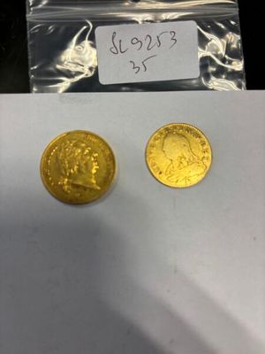 deux pièces d'or posées l'une à côté de l'autre sur une feuille de papier