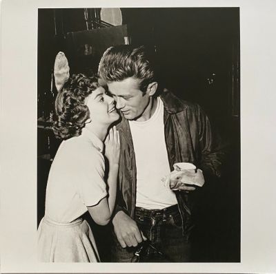 black and white photograph of a man kissing a woman in a kitchen