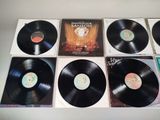 six black vinyl records sitting on top of each other on a table