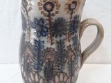a white and blue vase sitting on a white table