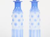 une paire de vases bleus et blancs posés sur des socles en bois, sur fond blanc