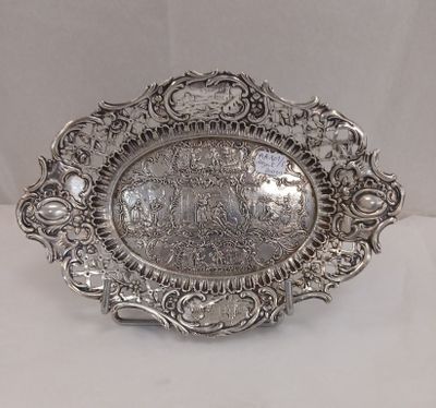 une assiette en argent sur laquelle est représenté un château