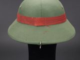 green hat with a red band on top of a black hat