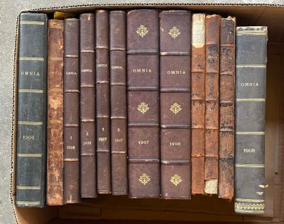 une boîte pleine de vieux livres posée sur le sol