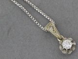 un gros plan d'un pendentif en diamant suspendu à une chaîne, posé sur une table