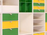 a white and yellow bookcase with green and yellow drawers