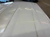 a white surfboard sitting on top of a car in a garage